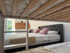 a bedroom with a loft bed with pink pillows at Apartment Herceg Blagaj in Blagaj