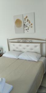 um quarto com uma cama branca com travesseiros brancos em Cozy and calm em Dhílesi