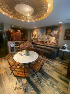 a living room with a table and chairs and a couch at Hotel Okako San Sebastian in San Sebasti&aacute;n