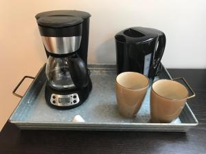 a coffee maker and two cups on a tray at Upper Room in the Mission in Kelowna