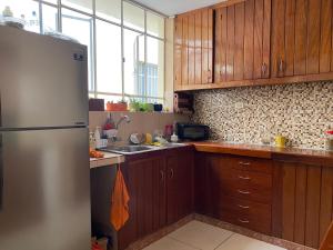 a kitchen with wooden cabinets and a stainless steel refrigerator at La Pascana Hospedaje in Cajamarca