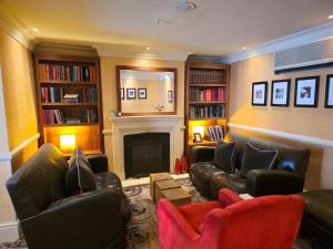 a living room with leather furniture and a fireplace at Hotel Manor - Datchet, Windsor in Windsor
