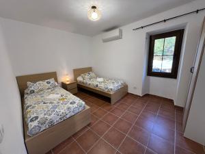 two twin beds in a room with a window at Casa Rural Can Ricós - El Mirador del Montseny in Vallgorguina +25 photos