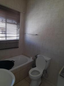 Un baño con inodoro, bañera y lavabo. en Boiketlong Stay, en Potchefstroom