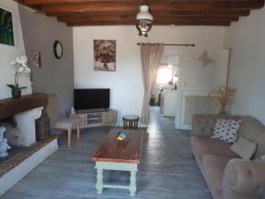 un soggiorno con un divano e un tavolino da caffè di Maison à la campagne - piscine a Beaulieu-sur-Layon