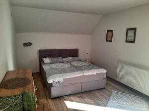 ein Schlafzimmer mit einem Bett und einem Holzboden in der Unterkunft Villa Luna Misevici in Hadžići