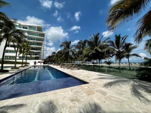 a swimming pool with palm trees and a building at Morros 922 Beach House in Cartagena de Indias