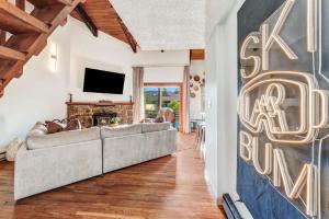 a living room with a couch and a tv at Ski Town Chalet in Steamboat Springs