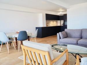 un soggiorno con un divano e un tavolo di Magnifique appartement T4 vue mer et parking privé a Le Touquet-Paris-Plage
