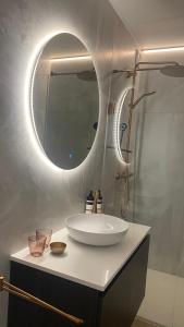 a bathroom with a white sink and a mirror at Orfeo Knokke in Knokke-Heist
