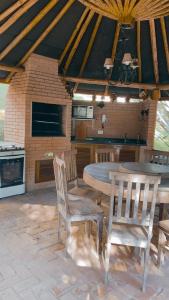 a patio with a table and chairs and a kitchen at Aconchegante Apartamento in Campos do Jordão