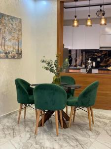 une salle à manger avec une table et des chaises vertes dans l'établissement Appartement de plage - Dahomey Beach - RDC, à Bouznika