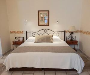 a bedroom with a large white bed and two night stands at Casa los Cantaros Hotel Boutique in Oaxaca City