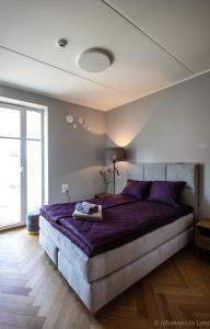a bedroom with a large bed with purple sheets at Sadama Guest Apartment in Haapsalu