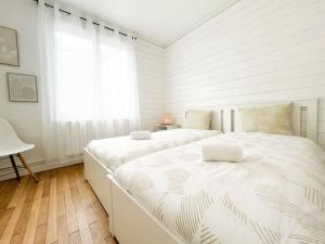 Un dormitorio blanco con dos camas y una ventana. en T2 Jardin, Centre, Gare, 5'plage, en Saint-Nazaire
