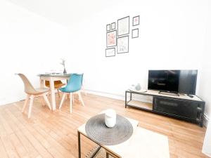 Una sala de estar con una mesa y un televisor. en T2 Jardin, Centre, Gare, 5'plage, en Saint-Nazaire