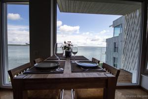 a wooden table with wine glasses and a view of the ocean at Sadama Guest Apartment in Haapsalu