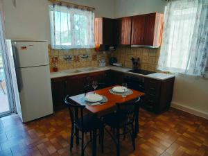 a kitchen with a table and chairs and a refrigerator at Takis apartment in Sparta