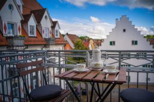 a table with two cups and a tea kettle on a balcony at Casa Burgplatz - Maisonettewohnung in Hüfingen +4 photos