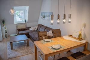 a living room with a table and a couch at Casa Burgplatz - Maisonettewohnung in Hüfingen