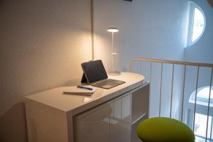 a laptop computer sitting on a white desk with a lamp at Casa Burgplatz - Maisonettewohnung in Hüfingen