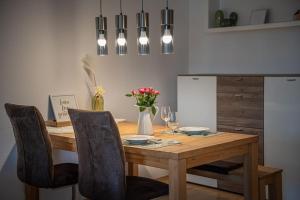 a dining room table with chairs and a table with wine glasses at Casa Burgplatz - Maisonettewohnung in Hüfingen