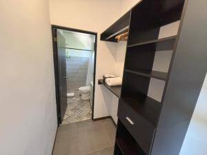 a bathroom with a black cabinet and a toilet at Amazilia Guesthouse in Liberia