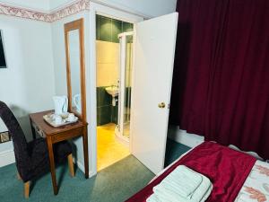 サウサンプトンにあるThe Bliss 7 Home Stay, En-suite, Self check-in with smart lock, Non Smoking Home in and out, Zero tolerance for noise after 11pmのベッドとテーブルと鏡のある寝室