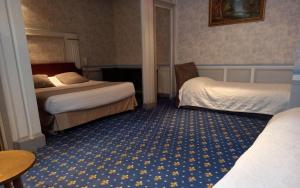 a hotel room with two beds and a table at Brit Hotel Comtes De Champagne - Troyes Centre Historique in Troyes