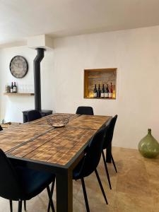 a dining room with a wooden table and chairs at Maison de village in Saint-Paulet-de-Caisson
