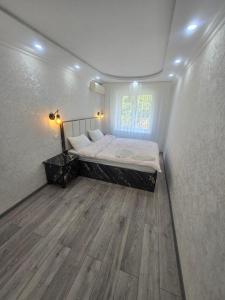 a bedroom with a bed and a wooden floor at Тихий уголок in Samarkand