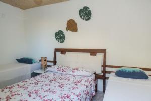 1 Schlafzimmer mit 2 Betten und 2 Pflanzen an der Wand in der Unterkunft Casa Vila do Sol - 4 suítes - Praia da Taíba in Taíba + 107 Fotos