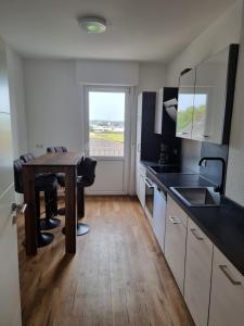 una cucina con tavolo in legno e un angolo cottura con frigorifero e piano cottura. di Die Insel a Osnabrück Altre 7 foto