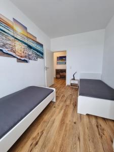 una camera da letto con due letti e pavimento in legno di Die Insel a Osnabrück