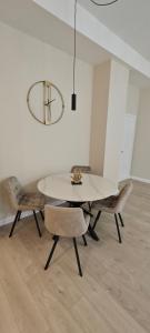 una sala da pranzo con tavolo e sedie bianchi di Apartamentai Viktorija a Klaipėda