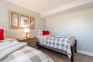 a bedroom with two beds and a table with a lamp at Fly Away Home in West Jordan