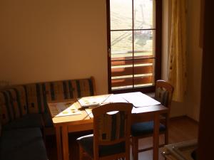 een kamer met een tafel, stoelen en een raam bij Rodinné Apartmány in Deštné v Orlických horách