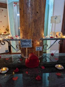 a table with a tree and a sign that reads enjoy at Pousada dos Veleiros in Nova Almeida +186 photos
