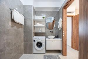 a bathroom with a washing machine and a mirror at Sunny Rock Apartments in Asfendioú