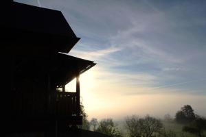 a silhouette of a building with the sun in the sky at Chata Johanka & Sauna in Jevíčko