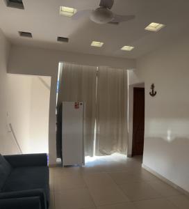 a living room with a ceiling fan and a refrigerator at Cantinho da Lili in Ubatuba +29 photos