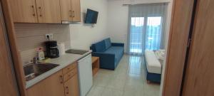 a kitchen with a sink and a blue chair at Anatoli Studios in Skala Rachoniou