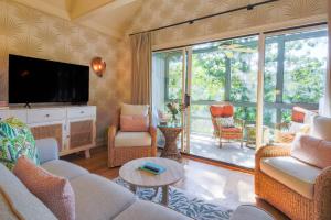 基洼岛Palm Bungalow的客厅里有一张沙发和一台电视