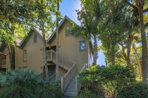 基洼岛Palm Bungalow的一座带楼梯的房子,通往树丛