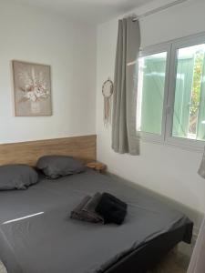 una cama en un dormitorio con ventana en L'Évidence, en Saint-Raphaël