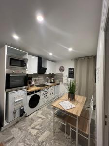 cocina con electrodomésticos de acero inoxidable y mesa de madera en L'Évidence, en Saint-Raphaël