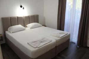 a bed with white sheets and pillows in a bedroom at Captain's View in Dobra Voda