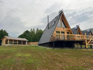 ein großes Holzhaus mit Mansarddach in der Unterkunft Păltinel in Braşov