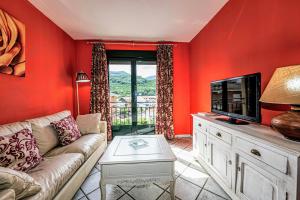 Una sala de estar con un sofá y un televisor. en Prado del abuelo, en Cabezuela del Valle