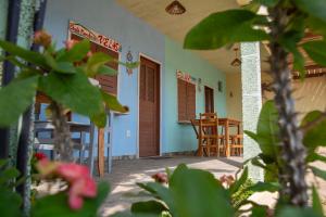 a porch of a house with chairs and a table at Chalés Panulirus in Icapuí